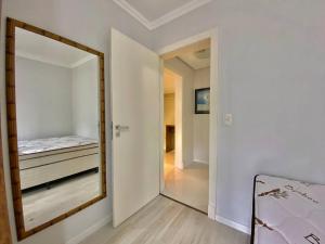 um quarto com um espelho e uma cama em Apartamento com fácil acesso ao Vale dos Vinhedos em Bento Gonçalves