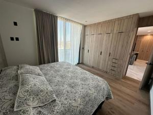 sypialnia z łóżkiem i dużym oknem w obiekcie Loft en WTower 503 Mazatlan w mieście Mazatlán