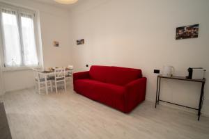 un divano rosso in soggiorno con tavolo di AG apartment a Cormano