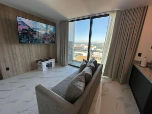 salon z kanapą i dużym oknem w obiekcie Loft en WTower 503 Mazatlan w mieście Mazatlán