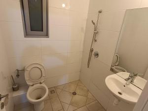 a bathroom with a toilet and a sink at Lovely room at Benny's apartment in Netivot