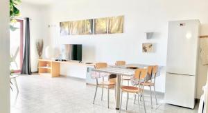 cocina blanca con mesa y sillas en Sun Dreams Ericeira Apartment, en Ericeira