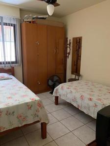 A bed or beds in a room at APTO PRAIA DO MORRO, 02 QUARTOS C SUITE, WI-FI, GARAGEM, 1 ANDAR ESCADA.