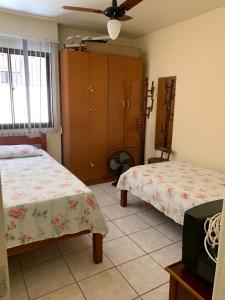 a bedroom with two beds and a ceiling fan at APTO PRAIA DO MORRO, 02 QUARTOS C SUITE, WI-FI, GARAGEM, 1 ANDAR ESCADA. in Guarapari