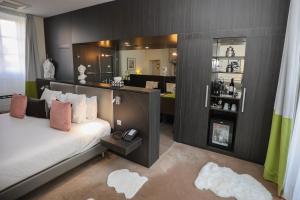 a bedroom with a bed with a mirror and a bathroom at Hôtel Château de Lacan in Brive-la-Gaillarde