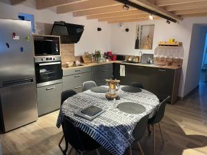a kitchen with a table and a refrigerator at Gîte cévenol pleine nature tout confort in Soudorgues +10 photos