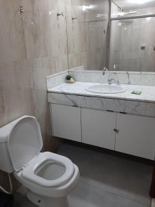 a bathroom with a white toilet and a sink at Apartamento 2010 in Goiânia