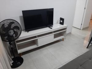 a flat screen tv sitting on top of a entertainment center at Apartamento 2010 in Goiânia