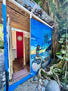 a mural of a mermaid on the side of a house at Casa Mariposa in Puerto Viejo