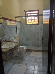 a bathroom with a sink and a toilet and a window at Pousada do Bosque in Rio das Ostras