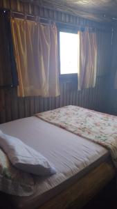 Cette chambre comprend un grand lit et une fenêtre. dans l'établissement Sobradinho Nova Torres, 