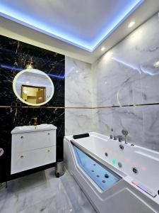 y baño con bañera, lavabo y espejo. en Apartament Chill & Lux, en Ostróda
