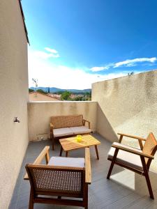 d'une terrasse avec 2 chaises et une table sur un balcon. dans l'établissement Chaleureuse maison avec terrasse et garage, à Espira-de-lʼAgly