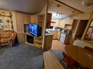 a small kitchen with a living room with a tv in it at Willerby Holiday Home in Durham