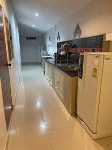 a kitchen with a white refrigerator in a room at The phoenix kanchanaburi in Kanchanaburi