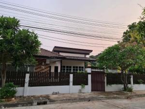 a house with a white fence and trees at The phoenix kanchanaburi in Kanchanaburi