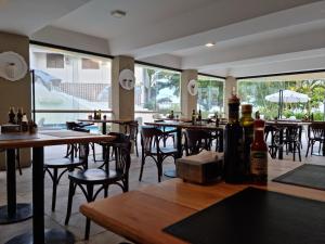 um restaurante com mesas e cadeiras e garrafas de vinho em Praia Brava Hotel em Florianópolis