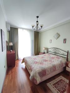 um quarto com uma cama e uma grande janela em Резиденция Изумруд em Baku