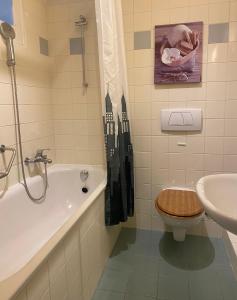 La salle de bains est pourvue d'une baignoire, de toilettes et d'un lavabo. dans l'établissement HOCORAS Apartment, à Genève