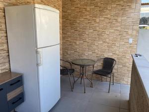 uma cozinha com um frigorífico e uma mesa com cadeiras em Chácara Casa da Paz em Suzano