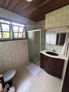 a bathroom with a sink and a shower at Pousada House Sol & Praia in Torres