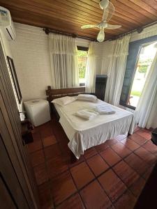 a bedroom with a bed and a ceiling fan at Pousada House Sol & Praia in Torres