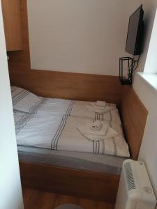 una cama con sábanas blancas y una televisión en ella en Planinski Raj - Bela Reka Gondola en Brzeće