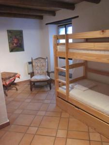 a room with two bunk beds and a chair at Ostello Orgnana in Magadino