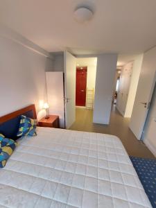 1 dormitorio grande con 1 cama blanca grande y pasillo en Santiago Rooms en Caminha
