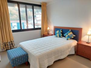 a bedroom with a bed and a large window at Santiago Rooms in Caminha