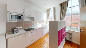 a kitchen with white cabinets and a large window at Quieter Studios Centre of Nottingham in Nottingham