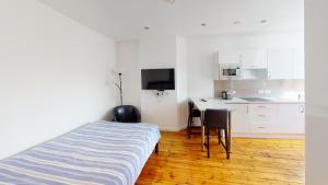 a bedroom with a bed and a table and a kitchen at Quieter Studios Centre of Nottingham in Nottingham