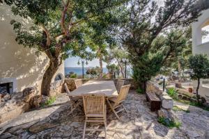 einen Tisch und Stühle auf einer steinernen Terrasse mit einem Baum in der Unterkunft Villa Salanti in Koilás