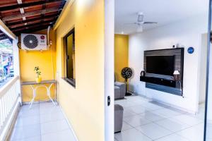 een woonkamer met gele muren en een tv bij PV Marimbondo's House I in Itacaré