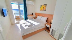 a bedroom with a bed and a large window at Midilli Konak Foca in Foça