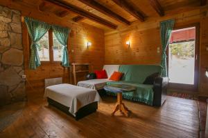 Una sala de estar con un sofá verde y una mesa. en Cabin Drveni Kutak, en Sekulić 