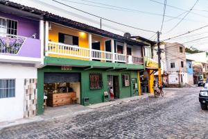 een kleurrijk gebouw aan de kant van een straat bij PV Marimbondo's House I in Itacaré