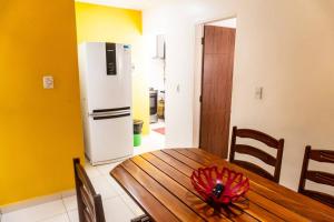 een keuken met een houten tafel en een koelkast bij PV Marimbondo's House I in Itacaré