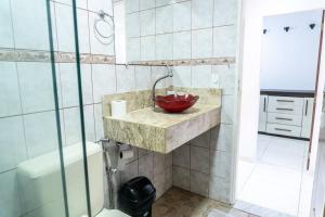 een badkamer met een wastafel met een rode kom erop bij PV Marimbondo's House I in Itacaré +22 foto's