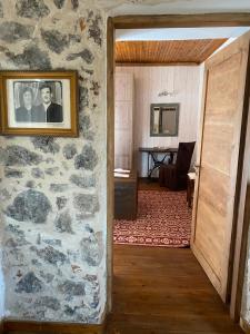 ein Zimmer mit einer Steinmauer mit einem Bild an der Wand in der Unterkunft Ypsus House Stemnitsa in Stemnitsa