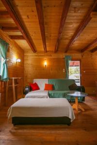Un dormitorio con una cama y un sofá en una habitación. en Cabin Drveni Kutak, en Sekulić 