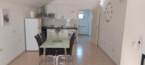 eine Küche und ein Esszimmer mit einem Tisch und Stühlen in der Unterkunft Apartman Marina in Murvica