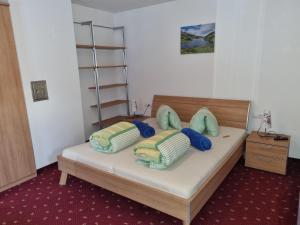 a bedroom with a bed with blue and green pillows at Ferienwohnung Anita in Sankt Gallenkirch