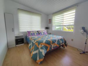 a bedroom with a bed and a fan in it at Casa shalet piriapolis 6 personas in Bella Vista