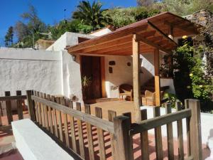 a wooden house with a fence in front of it at Casas cuevas, Los Cabucos in Agaete