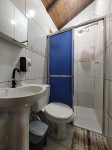 a bathroom with a toilet and a sink and a shower at Pousada e Camping do Clodo in Ilha do Mel