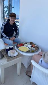 Un uomo seduto accanto a un tavolo con un vassoio di cibo di AQABA PRO DIVERS ad Aqaba