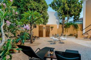 a courtyard with chairs and tables and trees at Kristina´s Apartments in Rhodes Town