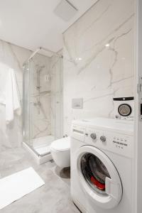 a white bathroom with a washing machine and a toilet at Seba Suites with Fitness And Pool in Istanbul