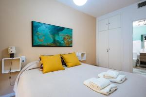 a bedroom with a white bed with towels on it at ROMANTICO APARTAMENTO SEVILLA in Seville